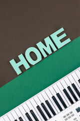 Fototapeta premium Musical keys and decorative word home on a colored background.