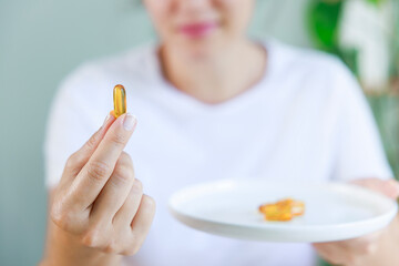 Woman showing vitamin capsule