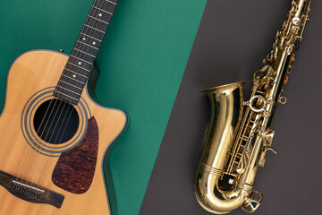 Guitar and saxophone on paper background, top view.
