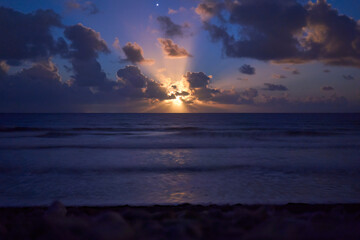 Fototapeta na wymiar Moonset over the sea. Celestial body and Venus star in cloudy night sky.