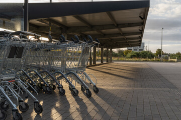 Metal supermarket carts in a parking lot empty