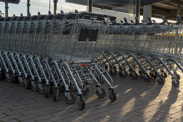 Metal supermarket carts in a parking lot empty