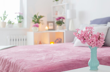 pink and white interior of bedroom with spring flowers