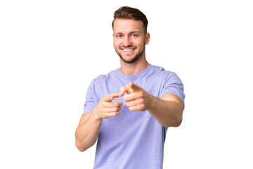 Young handsome caucasian man over isolated chroma key background surprised and pointing front