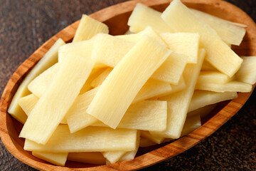 Sliced canned bamboo shoots in wooden bowl