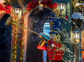 Big nutcracker playing music on trumpet outdoor. Christmas toy on street on winter holiday, Xmas eve