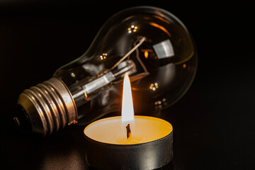 Electric lamp and candle on a dark background. Incandescent lamp and candle. No or power outage....