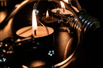 Electric lamp and candle on a dark background. Incandescent lamp and candle. No or power outage....