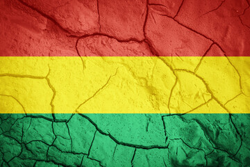 Flag of Bolivia. Bolivian symbol. Flag on the background of dry cracked earth. Bolivian flag with drought concept