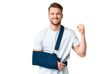 Young caucasian man with broken arm and wearing a sling over isolated chroma key background celebrating a victory