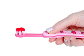 Children's pink toothbrush with toothpaste in hand on white background isolation