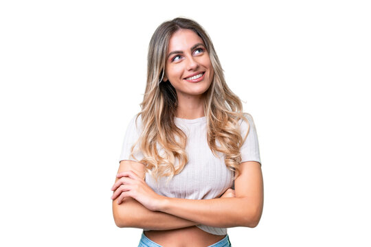 Young Uruguayan woman over isolated background looking up while smiling