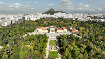 Obraz premium Aerial drone photo of renovated public neoclassic building of Zappeion used for events and meetings in the National Gardens of Athens and Lycabettus hill aligned at the background, Greece