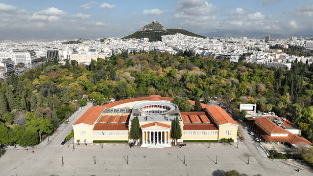 Aerial drone photo of renovated public neoclassic building of Zappeion used for events and meetings in the National Gardens of Athens and Lycabettus hill aligned at the background, Greece