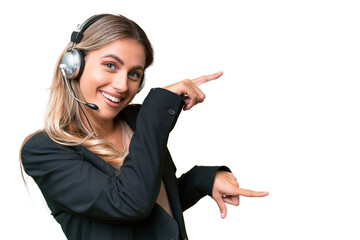 Telemarketer pretty Uruguayan woman working with a headset over isolated background pointing finger...