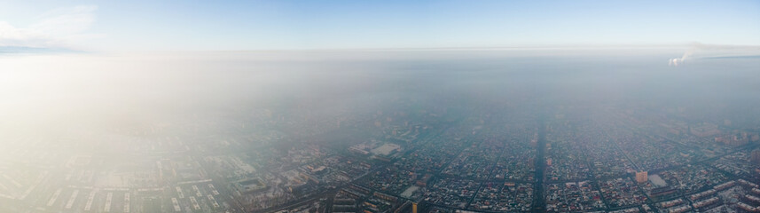Panoramic aerial view of polluted city covered with smog