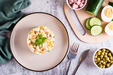 Olivier salad on a plate ingredients for its preparation on the table. Christmas snacks. Top view