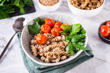 Boiled buckwheat pasta, tomatoes and parsley in a bowl on the table. Alternative diet