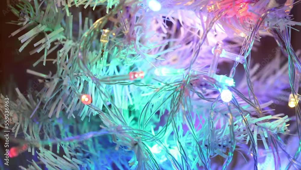 Aufkleber multi-colored flashing garland on the branches of a white christmas tree