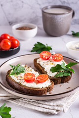 Appetizing bruschetta with ricotta, tomatoes, flax seeds and parsley on a plate. Vertical view