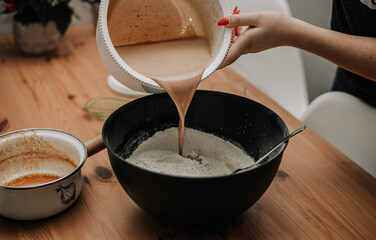 Wlewanie ciasta do mąki na świąteczne pierniki