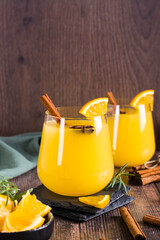 Orange grog with cinnamon and cardamom in glasses on the table. Homemade drinks. Vertical view