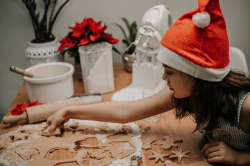 Dzieci wycinają wzroki z ciasta na świąteczne ciastka dla mikołaja - obrazy, fototapety, plakaty
