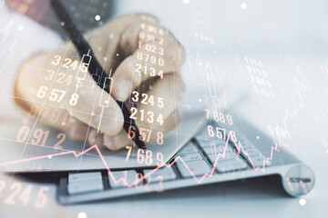 Double exposure of abstract creative statistics data hologram with hand writing in notepad on background with laptop, analytics and forecasting concept