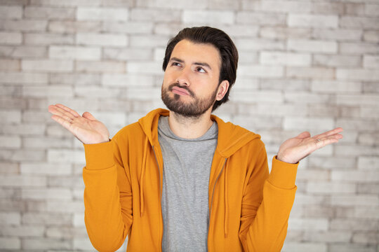 young man gesturing on wallpaper background