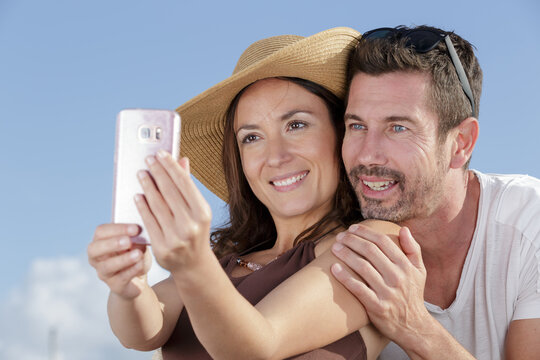 portrait of cheerful mature couple taking selfie picture