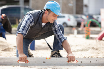 male construction worker levelling sand