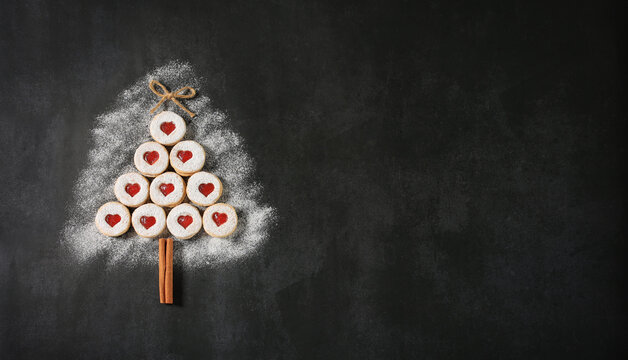 Strawberry jam cookies sprinkled with powdered sugar, cinnamon stick, bow-shaped twine, place for text