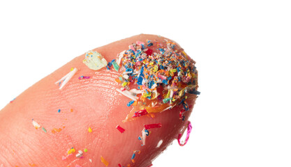 Fototapeta premium Microplastics in water - polluted water - macro photography of finger with microplatics peaces