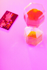 Bank card and hourglass on a purple background. Sandglass and credit card in neon light. Time is money concept