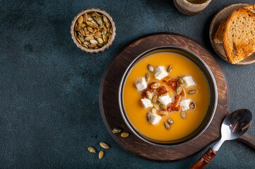 Pumpkin soup with feta and tomatoes. Soup with seeds. Carrot soup with cheese. Vegetarian soup.