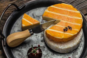 cream Round brie or camambert cheese on a wooden board. Rougette cheese on a wooden background,...
