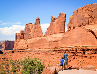 Father and son go hike between the rocks of arches national park