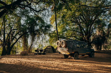 Campingidylle - Familie zeltet in einem lichten Wald am Kunene River, Namibia