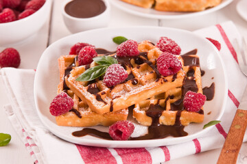 Waffles with raspberries and chocolate cream.