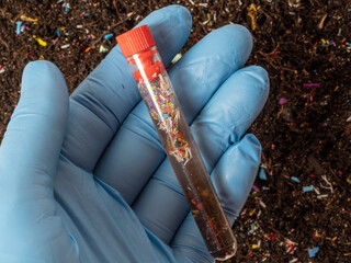 Microplastics in soil a test tube with soil sample - soil contaminated with mineral microplastics