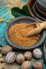 Nutmeg powder. Macro view whole nuts and grated muscat nuts on vintage background.