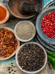 Indian spices collection, dried black peppercorns and another spices in clay bowls
