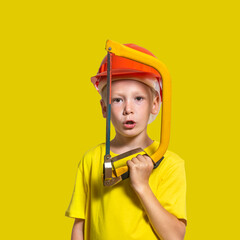 a child in a construction helmet and a hacksaw in his hands on a white background