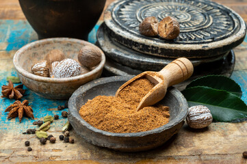 Nutmeg powder. Macro view whole nuts and grated muscat nuts on vintage background.