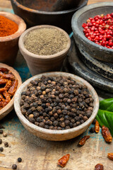 Indian spices collection, dried black peppercorns and another spices in clay bowls