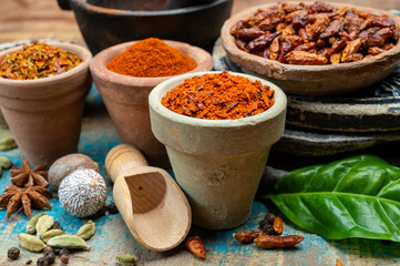 Colorful ground spicy chili peppers , pimento and curcuma is clay pots close up