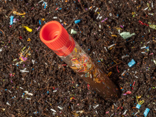 Obraz premium Microplastics in soil a test tube with soil sample - soil contaminated with mineral microplastics