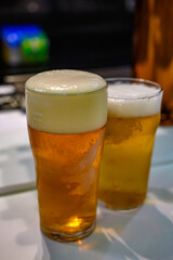 Fresh draught lager or IPA beer is glass served in indoor cafe close up, pint of beer