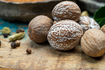 Nutmeg powder. Macro view whole nuts and grated muscat nuts on vintage background.