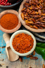 Colorful ground spicy chili peppers , pimento and curcuma is clay pots close up